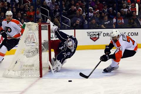 Dec 19, 2015; Columbus, OH, USA; Columbus Blue Jackets goalie Joonas Korpisalo (70) dives back to the goal as Philadelphia Flyers right wing Pierre-Edouard Bellemare (78) reaches for the loose puck during the first period at Nationwide Arena. Mandatory Credit: Russell LaBounty-USA TODAY Sports