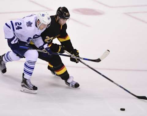 Feb 13, 2016; Vancouver, British Columbia, CAN; Vancouver Canucks defenseman Ben Hutton (27) battles for the puck against Toronto Maple Leafs forward Peter Holland (24) during the third period at Rogers Arena. The Toronto Maple Leafs won 5-2. Mandatory Credit: Anne-Marie Sorvin-USA TODAY Sports