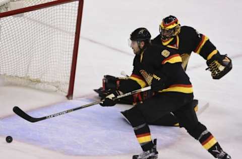 Feb 13, 2016; Vancouver, British Columbia, CAN; Vancouver Canucks defenseman Christopher Tanev (8) reaches for the puck after a shot on net by the Toronto Maple Leafs during the second period at Rogers Arena. Mandatory Credit: Anne-Marie Sorvin-USA TODAY Sports