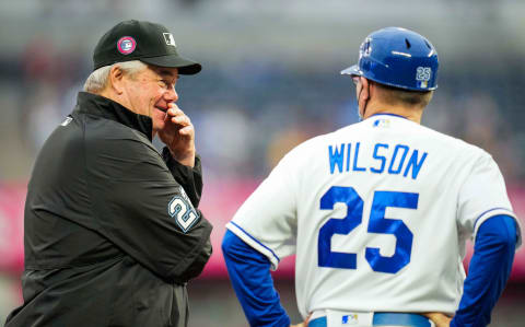 May 31, 2021; Kansas City, Missouri, USA; Umpire Joe West (22) talks with Kansas City Royals third base coach Vance Wilson (25) during the second inning at Kauffman Stadium. Mandatory Credit: Jay Biggerstaff-USA TODAY Sports