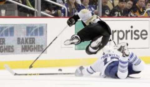 Oct 17, 2015; Pittsburgh, PA, USA; Pittsburgh Penguins defenseman Kris Letang (top) is tripped by Toronto Maple Leafs right wing P.A. Parenteau (15) during the third period at the CONSOL Energy Center. The Penguins won 2-1. Mandatory Credit: Charles LeClaire-USA TODAY Sports