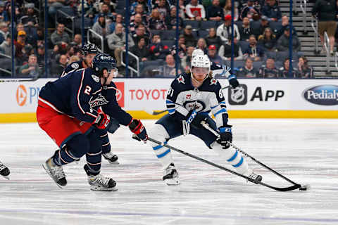 Feb 16, 2023; Columbus, Ohio, USA; Winnipeg Jets left wing Kyle Connor (81) carries the puck as Columbus Blue Jackets defenseman Andrew Peeke (2) defends during the first period at Nationwide Arena. Mandatory Credit: Russell LaBounty-USA TODAY Sports