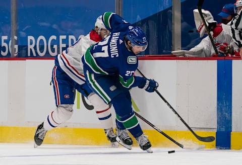 VANCOUVER, BC – JANUARY 20: Travis Hamonic #27 of the Vancouver Canucks checks Jonathan Drouin #92 of the Montreal Canadiens off the puck during NHL hockey action at Rogers Arena on January 20, 2021 in Vancouver, Canada. (Photo by Rich Lam/Getty Images)