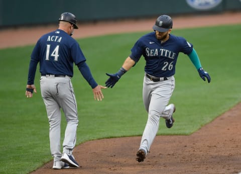 MINNEAPOLIS, MINNESOTA – APRIL 08: Third base coach Manny Acta #14 of the Seattle Mariners congratulates Jose Marmolejos #26 on his solo home run against the Minnesota Twins during the sixth inning of the home opening game at Target Field on April 8, 2021 in Minneapolis, Minnesota. The Twins defeated the Mariners 10-2. (Photo by Hannah Foslien/Getty Images)