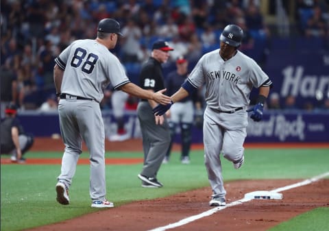 Jul 4, 2019; St. Petersburg, FL, USA; New York Yankees designated hitter Edwin Encarnacion (30) is congratulated by third base coach Phil Nevin (88) as he hits a home run during the seventh inning against the Tampa Bay Rays at Tropicana Field. Mandatory Credit: Kim Klement-USA TODAY Sports