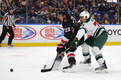 Jan 7, 2023; Buffalo, New York, USA; Buffalo Sabres defenseman Owen Power (25) and Minnesota Wild right wing Ryan Reaves (75) go after a loose puck during the first period at KeyBank Center. Mandatory Credit: Timothy T. Ludwig-USA TODAY Sports