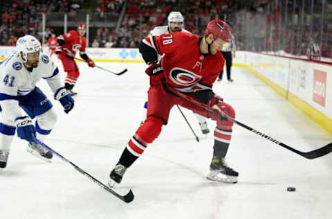 RALEIGH, NORTH CAROLINA – MARCH 22: Steven Lorentz #78 of the Carolina Hurricanes keeps the puck away from Pierre-Edouard Bellemare #41 of the Tampa Bay Lightning during the first period at PNC Arena on March 22, 2022, in Raleigh, North Carolina. (Photo by Eakin Howard/Getty Images)