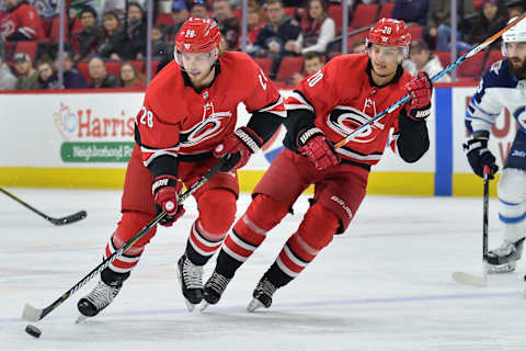 RALEIGH, NC – MARCH 04: Carolina Hurricanes Left Wing Sebastian Aho (20) and Carolina Hurricanes Center Elias Lindholm (28) bring a puck up the ice during a game between the Winnipeg Jets and the Carolina Hurricanes at the PNC Arena in Raleigh, NC on March 4, 2018. Winnipeg defeated Carolina 3-2. (Photo by Greg Thompson/Icon Sportswire via Getty Images)