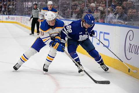 Mar 13, 2023; Toronto, Ontario, CAN; Buffalo Sabres defenseman Henri Jokiharju (10) battles with Toronto Maple Leafs forward William Nylander (88) along the boards during the third period at Scotiabank Arena. Mandatory Credit: John E. Sokolowski-USA TODAY Sports