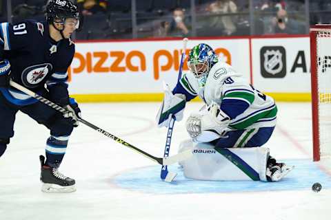 Jan 27, 2022; Winnipeg, Manitoba, CAN; Winnipeg Jets forward Cole Perfetti (91) looks for the rebound off Vancouver Canucks goalie Spencer Martin (30) during the second period at Canada Life Centre. Mandatory Credit: Terrence Lee-USA TODAY Sports