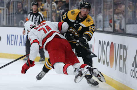 BOSTON, MASSACHUSETTS – MAY 06: Brad Marchand #63 of the Boston Bruins collides with Jaccob Slavin #74 of the Carolina Hurricanes during the second period of Game Three of the First Round of the 2022 Stanley Cup Playoffs at TD Garden on May 06, 2022, in Boston, Massachusetts. (Photo by Maddie Meyer/Getty Images)