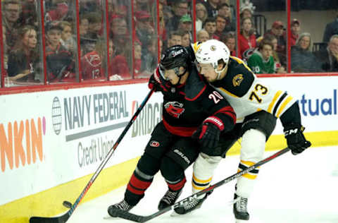 RALEIGH, NC – MAY 16: Sebastian Aho #20 of the Carolina Hurricanes looks to gain control of a puck along the boards at Charlie McAvoy #73 of the Boston Bruins defends in Game Four of the Eastern Conference Third Round during the 2019 NHL Stanley Cup Playoffs on May 16, 2019 at PNC Arena in Raleigh, North Carolina. (Photo by Gregg Forwerck/NHLI via Getty Images)