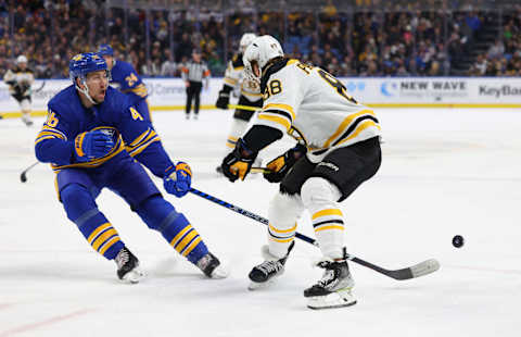 Mar 19, 2023; Buffalo, New York, USA; Buffalo Sabres defenseman Ilya Lyubushkin (46) knocks the puck off the stick of Boston Bruins right wing David Pastrnak (88) during the first period at KeyBank Center. Mandatory Credit: Timothy T. Ludwig-USA TODAY Sports