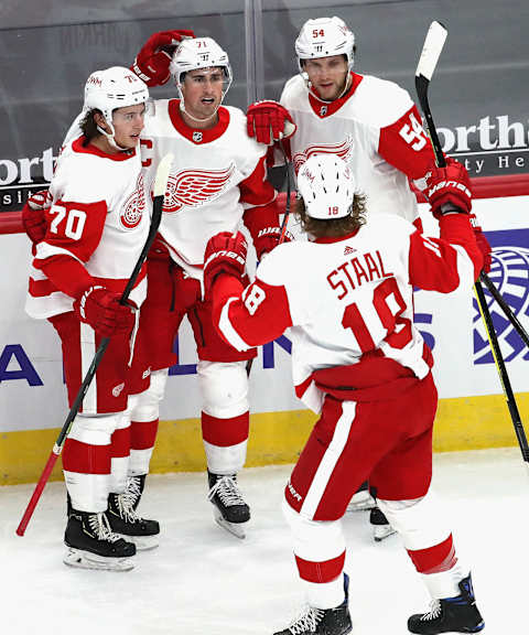 CHICAGO, ILLINOIS – JANUARY 22: Dylan Larkin #71 of the Detroit Red Wings (center) celebrates a third period goal with teammates (L-R) Troy Stecher #70, Bobby Ryan #54 and Marc Staal #18 against the Chicago Blackhawks at the United Center on January 22, 2021 in Chicago, Illinois. The Blackhawks defeated the Red Wings 4-1. (Photo by Jonathan Daniel/Getty Images)