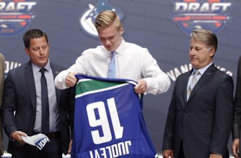 Jun 24, 2016; Buffalo, NY, USA; Olli Juolevi puts on a team jersey after being selected as the number five overall draft pick by the Vancouver Canucks in the first round of the 2016 NHL Draft at the First Niagra Center. Mandatory Credit: Timothy T. Ludwig-USA TODAY Sports