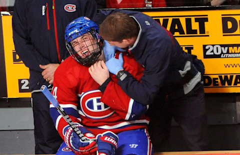 Jan 17, 2013; Montreal, QC, CAN; Montreal Canadiens defenseman Alexei Yemelin (74) gets checked out by trainer Graham Rynbend after taking a puck to the neck area during the second period at the Bell Centre. Mandatory Credit: Eric Bolte-USA TODAY Sports