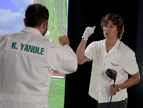 LAS VEGAS, NEVADA – SEPTEMBER 16: NHL player Keith Yandle (L), dressed as a golf caddie, fist bumps Trevor Zegras of the Anaheim Ducks at a golf simulator during the 2022 NHL player media tour at Encore Las Vegas on September 16, 2022 in Las Vegas, Nevada. (Photo by Ethan Miller/Getty Images)