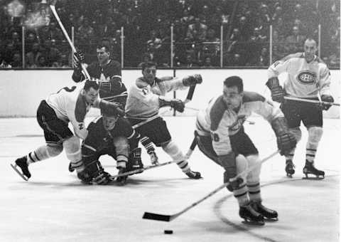 Canadian professional hockey players and Montreal Canadiens teammates Doug Harvey (#2) (1924 – 1989) and Dickie Moore (#12) attempt to block an opposing player from the Toronto Maple Leafs . (Photo by Robert Riger/Getty Images)