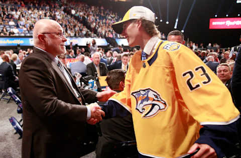 NASHVILLE, TENNESSEE - JUNE 29: Kalan Lind shakes hands with Barry Trotz after being selected 46th overall by the Nashville Predators during the 2023 Upper Deck NHL Draft - Rounds 2-7 at Bridgestone Arena on June 29, 2023 in Nashville, Tennessee. (Photo by Jeff Vinnick/NHLI via Getty Images)