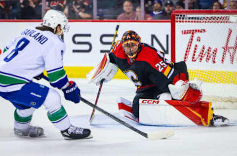 Dec 14, 2022; Calgary, Alberta, CAN; Calgary Flames goaltender Jacob Markstrom (25) makes a save against Vancouver Canucks right wing Conor Garland (8) during the overtime period at Scotiabank Saddledome. Mandatory Credit: Sergei Belski-USA TODAY Sports