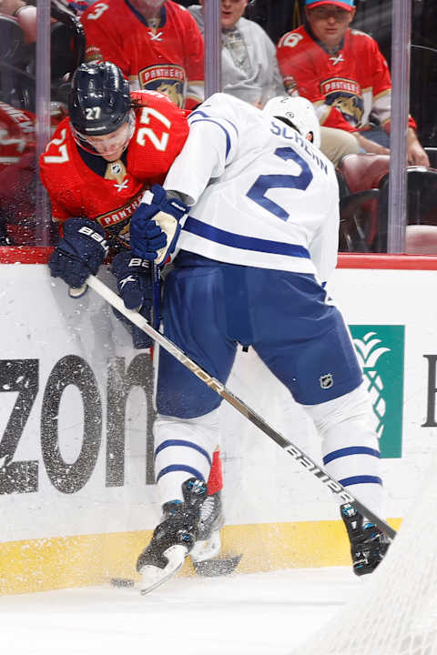 SUNRISE, FL – APRIL 10: Luke Schenn #2 of the Toronto Maple Leafs checks Eetu Luostarinen #27 of the Florida Panthers off the puck at the FLA Live Arena on April 10, 2023 in Sunrise, Florida. (Photo by Joel Auerbach/Getty Images)