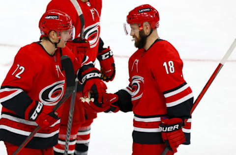 RALEIGH, NORTH CAROLINA – DECEMBER 16: Jack Drury #72 of the Carolina Hurricanes is presented the game puck by his teammate Derek Stepan #18 following the game against the Detroit Red Wings at PNC Arena on December 16, 2021, in Raleigh, North Carolina. (Photo by Jared C. Tilton/Getty Images)