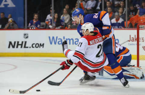 BROOKLYN, NY – APRIL 26: New York Islanders defenseman Scott Mayfield (24) stays strong in front of his net and takes down Carolina Hurricanes right wing Nino Niederreiter (21) during game one of round two of the Stanley Cup Playoffs between the New York Islanders and the Carolina Hurricanes on April 26, 2019 at the Barclays Center in Brooklyn, NY. (Photo by John McCreary/Icon Sportswire via Getty Images)