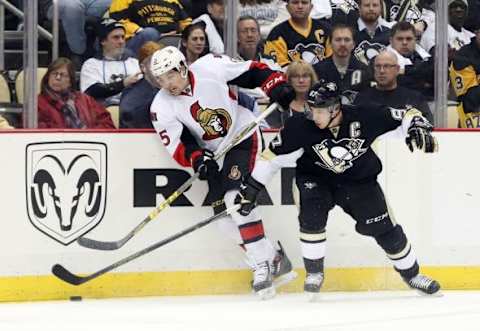 Feb 2, 2016; Pittsburgh, PA, USA; Ottawa Senators defenseman Cody Ceci (5) and Pittsburgh Penguins center Sidney Crosby (87) battle for the puck during the second period at the CONSOL Energy Center. The Penguins won 6-5. Mandatory Credit: Charles LeClaire-USA TODAY Sports