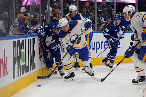 Mar 13, 2023; Toronto, Ontario, CAN; Buffalo Sabres defenseman Henri Jokiharju (10) battles with Toronto Maple Leafs forward Auston Matthews (34) for the puck during the first period at Scotiabank Arena. Mandatory Credit: John E. Sokolowski-USA TODAY Sports