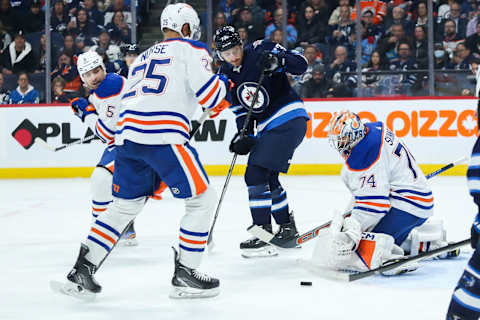 Nov 30, 2023; Winnipeg, Manitoba, CAN; Winnipeg Jets forward Gabriel Vilardi (13) and Edmonton Oilers goalie Stuart Skinner (74) look for the puck during the second period at Canada Life Centre. Mandatory Credit: Terrence Lee-USA TODAY Sports