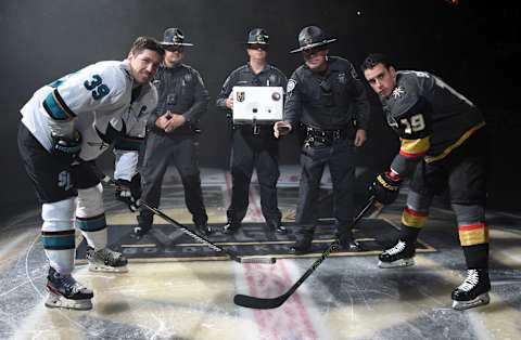 LAS VEGAS, NEVADA – OCTOBER 02: Reilly Smith #19 of the Vegas Golden Knights and Logan Couture #39 of the San Jose Sharks participate in a ceremonial puck drop with Nevada State Highway Patrol Officers prior to their opening night game at T-Mobile Arena on October 02, 2019 in Las Vegas, Nevada. (Photo by David Becker/NHLI via Getty Images)