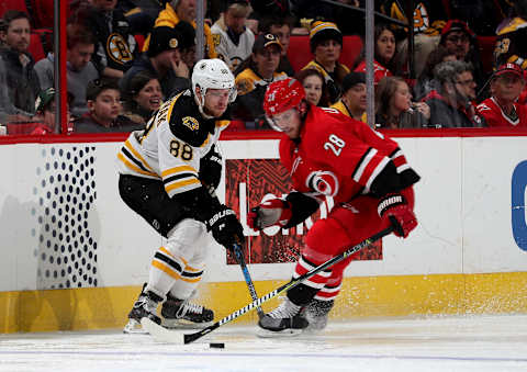 RALEIGH, NC – MARCH 13: Elias Lindholm #28 of the Carolina Hurricanes battles for control of a puck with David Pastrnak #88 of the Boston Bruins during an NHL game on March 13, 2018 at PNC Arena in Raleigh, North Carolina. (Photo by Gregg Forwerck/NHLI via Getty Images)