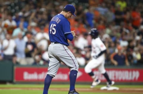 Sep 14, 2016; Houston, TX, USA; Texas Rangers starting pitcher Derek Holland (45) reacts as Houston Astros left fielder Teoscar Hernandez (35) rounds the bases after hitting a home run during the second inning at Minute Maid Park. Mandatory Credit: Troy Taormina-USA TODAY Sports