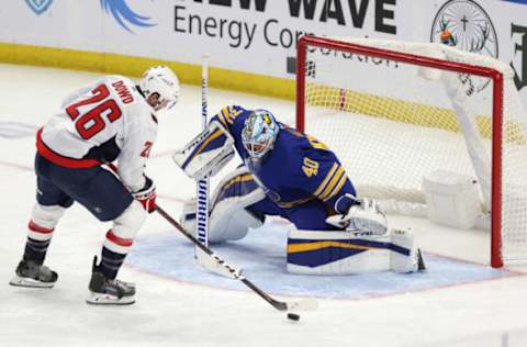 Jan 14, 2021; Buffalo, New York, USA; Buffalo Sabres goaltender Carter Hutton (40) looks to make a save on Washington Capitals center Nic Dowd (26) during the second period at KeyBank Center. Mandatory Credit: Timothy T. Ludwig-USA TODAY Sports