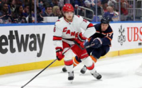 Jan 21, 2023; Elmont, New York, USA; Carolina Hurricanes defenseman Dylan Coghlan (15) controls the puck against New York Islanders left wing Matt Martin (17) during the second period at UBS Arena. Mandatory Credit: Brad Penner-USA TODAY Sports