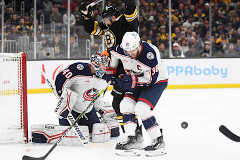 Dec 17, 2022; Boston, Massachusetts, USA; Columbus Blue Jackets center Boone Jenner (38) gets hit by the puck while battling with Boston Bruins left wing Nick Foligno (17) in front of goaltender Daniil Tarasov (40) during the first period at TD Garden. Mandatory Credit: Bob DeChiara-USA TODAY Sports