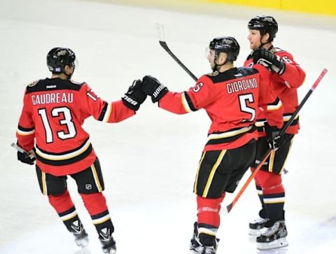 Oct 23, 2015; Calgary, Alberta, CAN; Calgary Flames defenseman Mark Giordano (5) celebrates his goal with forward Johnny Gaudreau (13) and defenseman Dennis Wideman (6) after scoring against Detroit Red Wings goaltender Jimmy Howard (35) (not pictured) during the first period at Scotiabank Saddledome. Mandatory Credit: Anne-Marie Sorvin-USA TODAY Sports