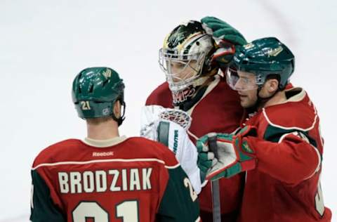 ST PAUL, MN – JANUARY 16: (L-R) Kyle Brodziak #21, Darcy Kuemper #35 and Nate Prosser #39 of the Minnesota Wild celebrate a win of the game against the Edmonton Oilers on January 16, 2014 at Xcel Energy Center in St Paul, Minnesota. The Wild defeated the Oilers 4-1. (Photo by Hannah Foslien/Getty Images)