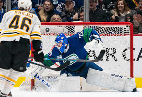 VANCOUVER, BC – FEBRUARY 22: Goalie Jacob Markstrom #25 of the Vancouver Canucks redirects the puck over his net as David Krejci #46 of the Boston Bruins looks on during NHL action at Rogers Arena on February 22, 2020 in Vancouver, Canada. (Photo by Rich Lam/Getty Images)