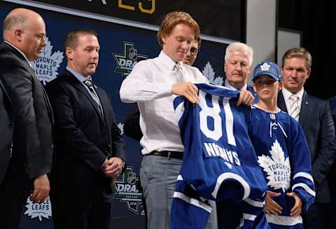 DALLAS, TX – JUNE 22: Rasmus Sandin puts on a Toronto Maple Leafs jersey after being selected twenty-ninth overall by the Toronto Maple Leafs during the first round of the 2018 NHL Draft at American Airlines Center on June 22, 2018 in Dallas, Texas. (Photo by Brian Babineau/NHLI via Getty Images)