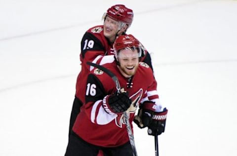 Feb 18, 2016; Glendale, AZ, USA; Arizona Coyotes right wing Shane Doan (19) and center Max Domi (16) celebrate after beating the Dallas Stars 6-3 at Gila River Arena. Mandatory Credit: Matt Kartozian-USA TODAY Sports