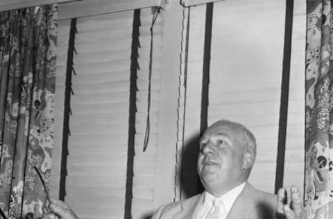 (Original Caption) Warren Giles, President of the National League, gestures as he looks over reports of the riot that took place during the second game of the July 18th doubleheader between the Cardinals and the Phillies. Giles examined the reports prior to a meeting with Umpires, Managers and players involved in the disputed game.