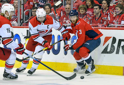 WASHINGTON, DC – APRIL 20: Carolina Hurricanes right wing Justin Williams (14) and Washington Capitals defenseman Nick Jensen (3) fight for a loose puck in the first period on April 20, 2019, at the Capital One Arena in Washington, D.C. in the first round of the Stanley Cup Playoffs. (Photo by Mark Goldman/Icon Sportswire via Getty Images)