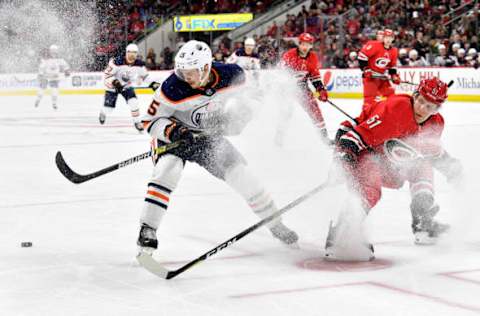 RALEIGH, NORTH CAROLINA – FEBRUARY 16: Josh Archibald #15 of the Edmonton Oilers moves the puck against Jake Gardiner #51 of the Carolina Hurricanes during the third period at PNC Arena on February 16, 2020, in Raleigh, North Carolina. The Oilers won 4-3 in overtime. (Photo by Grant Halverson/Getty Images)