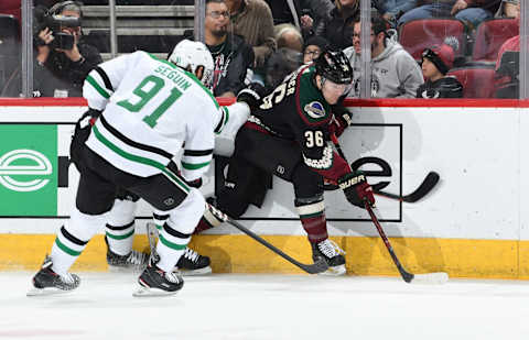 GLENDALE, AZ – FEBRUARY 09: Christian Fischer #36 of the Arizona Coyotes battls for the puck along the boards as Tyler Seguin #91 of the Dallas Stars skates in during the first period at Gila River Arena on February 9, 2019 in Glendale, Arizona. (Photo by Norm Hall/NHLI via Getty Images)