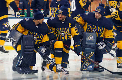 NASHVILLE, TENNESSEE - FEBRUARY 25: Juuse Saros #74 of the Nashville Predators speaks to teammates Roman Josi #59 and David Rittich #33 prior to a practice session before the 2022 Navy Federal Credit Union NHL Stadium Series at Nissan Stadium on February 25, 2022 in Nashville, Tennessee. (Photo by Frederick Breedon/Getty Images)