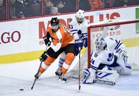 Jan 19, 2016; Philadelphia, PA, USA; Philadelphia Flyers center Sean Couturier (14) carries the puck against Toronto Maple Leafs center Nazem Kadri (43) and goalie James Reimer (34) during the third period at Wells Fargo Center. The Maple Leafs defeated the Flyers, 3-2. Mandatory Credit: Eric Hartline-USA TODAY Sports