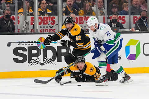 Nov 28, 2021; Boston, Massachusetts, USA; Boston Bruins right wing Craig Smith (12) and Boston Bruins center Charlie Coyle (13) and Vancouver Canucks center Justin Dowling (73) battle for the puck during the third period at TD Garden. Mandatory Credit: Gregory Fisher-USA TODAY Sports