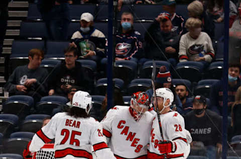 Columbus, OH – OCTOBER 23: Frederik Andersen #31 of the Carolina Hurricanes is congratulated by Ian Cole #28 and Ethan Bear #25 after defeating the Columbus Blue Jackets 5-1 at Nationwide Arena on October 23, 2021, in Columbus, Ohio. (Photo by Kirk Irwin/Getty Images)