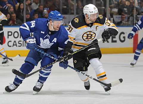 Patrice Bergeron #37 of the Boston Bruins battles against Morgan Rielly #44 of the Toronto Maple Leafs (Photo by Claus Andersen/Getty Images)